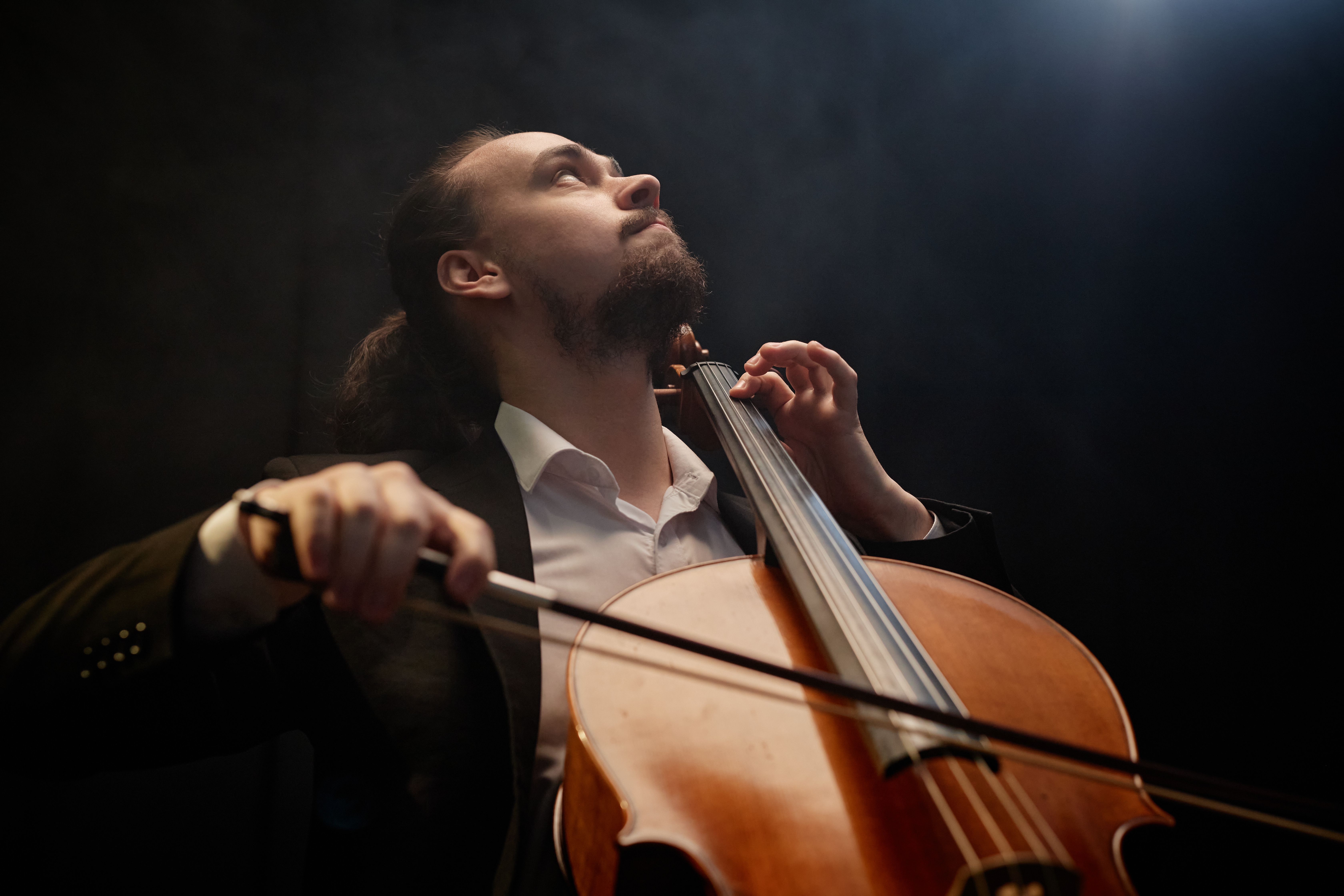 Professioneller Cellist beim Konzert in stimmungsvoller Beleuchtung